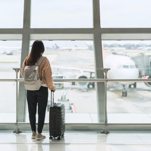 Mulher jovem num aeroporto a olhar aviões